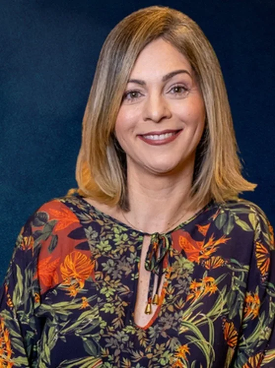 Dra. Monalisa Azevedo, sorrindo, de blusa estampada